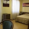 Una camera d'albergo con letto singolo e sedie.