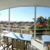 Tavoli all'aperto con vista su una spiaggia sabbiosa e giochi per bambini.