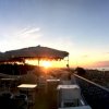 Tramonto su una terrazza di fronte alla spiaggia con ombrelloni.