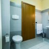 Un bagno moderno con piastrelle grigie e porta in legno.