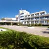 Un hotel moderno con giardino e cielo sereno.
