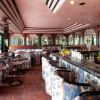 Un elegante bar con sedute colorate e specchi.