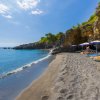 Spiaggia con ombrelloni e sedie a sdraio vicino alle rocce.