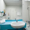 Bagno con lavandino bianco e vasca, arredamento blu.