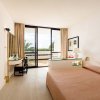 Stanza d'hotel con letto, scrivania e balcone.