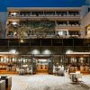 Esterno di un ristorante illuminato di sera, con tavoli apparecchiati.