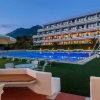 Piscina e sedie a sdraio davanti a un edificio moderno.