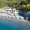 Spiaggia con ombrelloni e rocce circostanti.