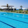 Piscina all'aperto con lettini e ombrelloni.