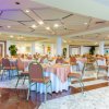 Sala ristorante con tavoli rotondi apparecchiati.