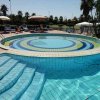 Piscina con gradini e ombrelloni in un giardino.