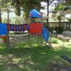 Parco giochi per bambini con altalena e scivolo colorati.