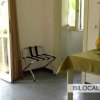 Interno di bilocale con tavolo e porta finestra aperta.