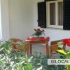 Patio esterno con tavolo, due sedie e piante.
