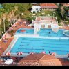Piscina con ombrelloni rossi e bianchi.