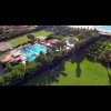 Vista aerea di un resort con piscine e verde.