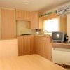 Piccola cucina con mobili in legno, televisore e aria condizionata.