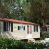 Casa mobile con finestre verdi tra gli alberi.