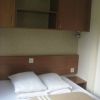 Camera da letto con letto matrimoniale, cuscini e armadietti in legno.