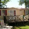 Una casa mobile con terrazza in legno, lettini e asciugamani appesi all'esterno.