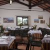 Sala da pranzo con tavoli apparecchiati, decorazioni floreali e quadri alle pareti.