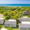 Case mobili in un campeggio vicino a una spiaggia e al mare.