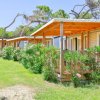 Bungalow con tetti in legno e giardini fioriti davanti.