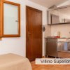Cucina con mobili in acciaio accanto a una porta marrone e finestra.