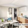 Interno di un lodge moderno con cucina, tavolo con sedie e divano.