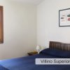 Camera da letto con letto matrimoniale, lampada e finestra con cornice di legno.