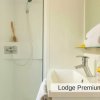 Bagno luminoso con doccia, lavandino e specchio. Asciugamani arrotolati e prodotto da bagno.