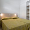 Camera da letto con letti singoli uniti e decorazioni gialle.