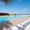 Piscina all'aperto con lettini bianchi.