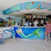 Bar colorato con decorazioni marine e persone che chiacchierano.