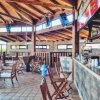 Bar accogliente con tetto in legno e sedie pieghevoli.