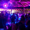 Persone che ballano in una discoteca con illuminazione blu e viola.