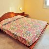 Letto matrimoniale con copriletto colorato in una stanza luminosa.