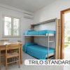 Letto a castello in una stanza con tavolo e sedie, finestra e porta sul giardino.