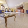 Hall di un hotel con un tavolino in legno e un bancone di ricevimento sullo sfondo.