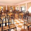 Sala da pranzo con tavoli e sedie vuoti.