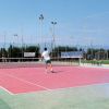 Campo da tennis all'aperto con persone che giocano.