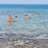 Persone che nuotano in mare cristallino vicino alla riva.