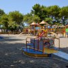 Parco giochi con scivoli colorati tra gli alberi.