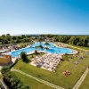 Ampia piscina con lettini su prato verde.