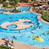 Piscina affollata con persone e gonfiabili gialli.