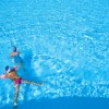 Due bambini galleggiano in piscina.