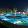 Piscina illuminata di notte con giochi d'acqua.