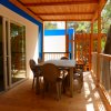 Veranda in legno con tavolo e sedie all'aperto.